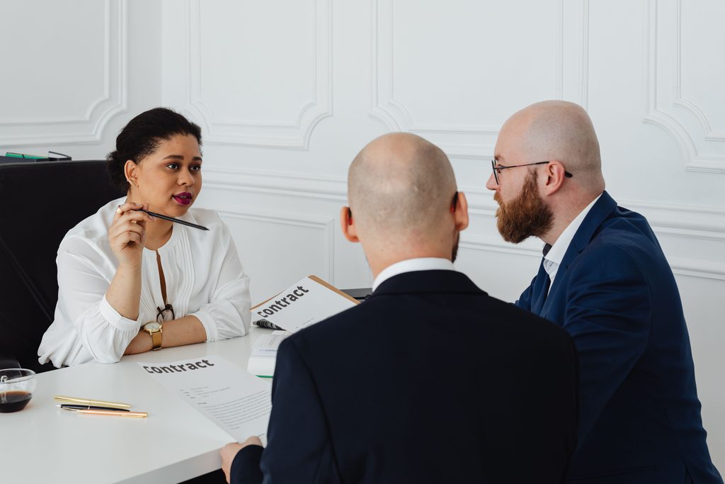 Profesionales revisando un contrato durante una conversación sobre condiciones laborales y transparencia salarial